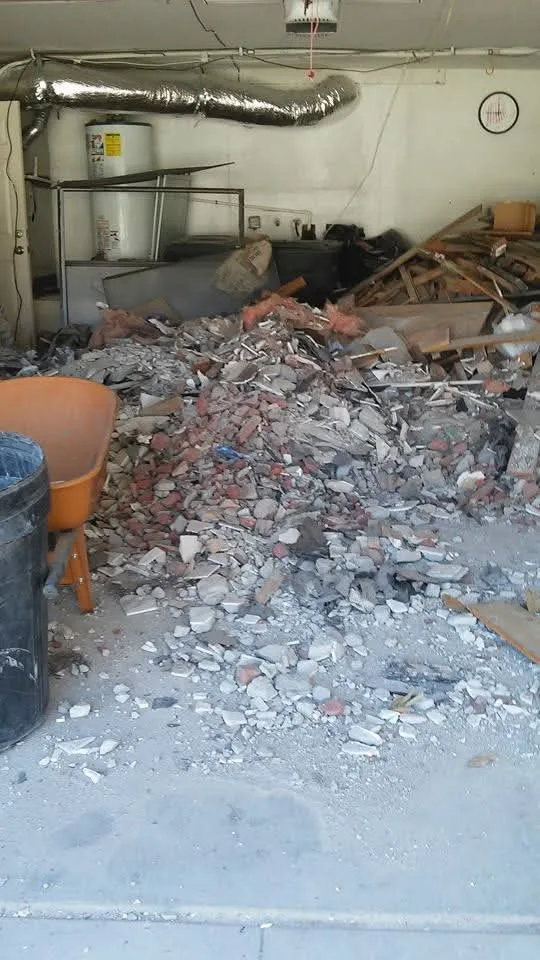 A garage floor buried in broken brick and concrete demolition debris